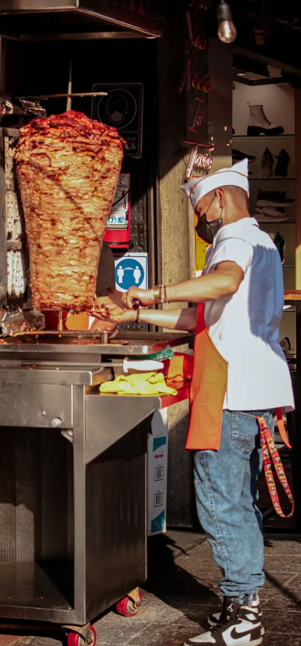 Al pastor on the spit being carved